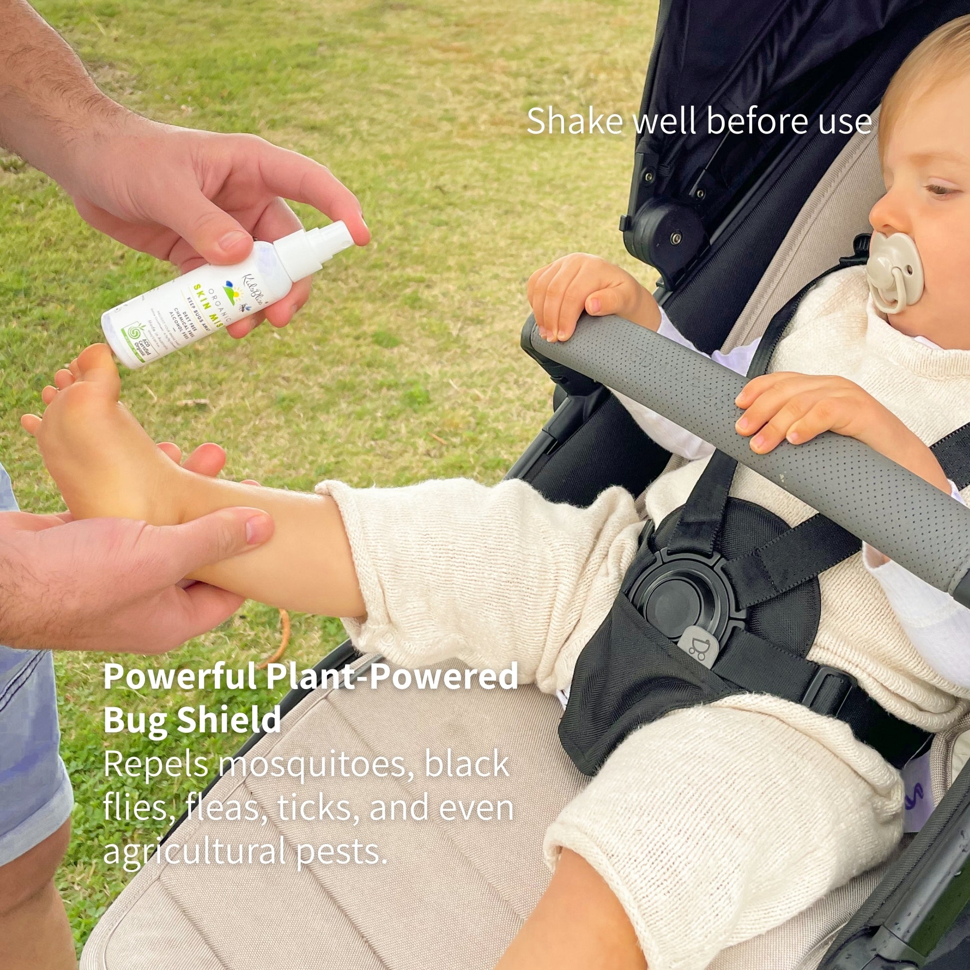 Person applying a plant-powered bug shield to a child's foot in a stroller.