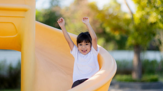 Child playing on a slide, representing fun and outdoor activities in the context of sunscreen myths sun safety.